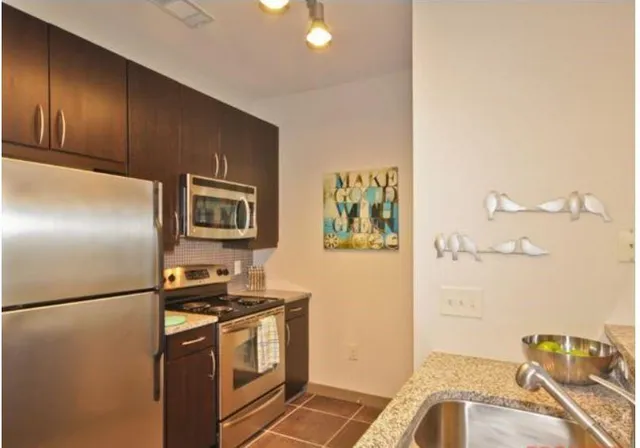 a kitchen with stainless steel appliances granite countertop a refrigerator sink and stove