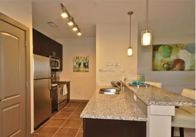 a kitchen with stainless steel appliances granite countertop a sink a refrigerator and a stove