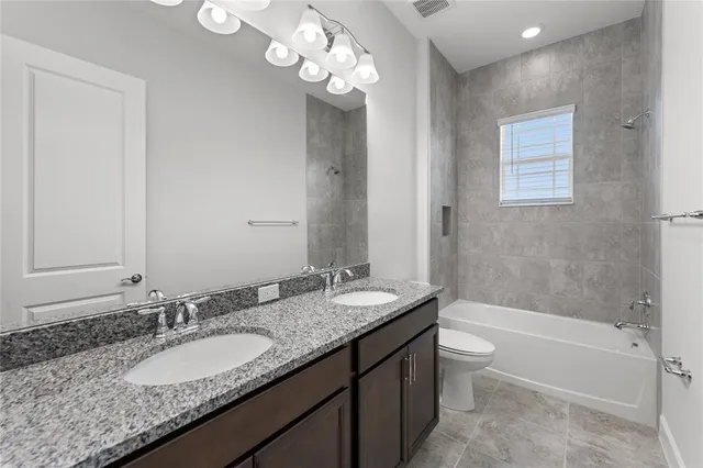 a bathroom with a granite countertop bathtub a sink and a mirror