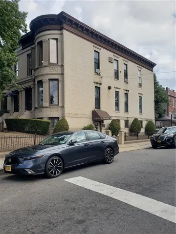 a car parked in front of a white house