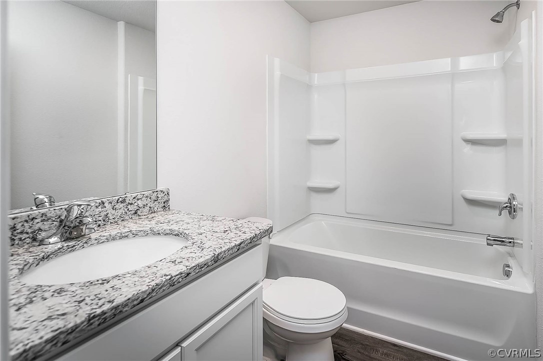 17266 George Ruffin Road Milford, VA 22514 - Photo 11 of 12 a bathroom with a granite countertop sink a toilet and bathtub