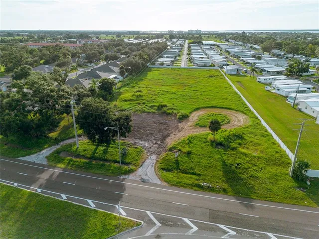 an aerial view of a residential houses with outdoor space and trees