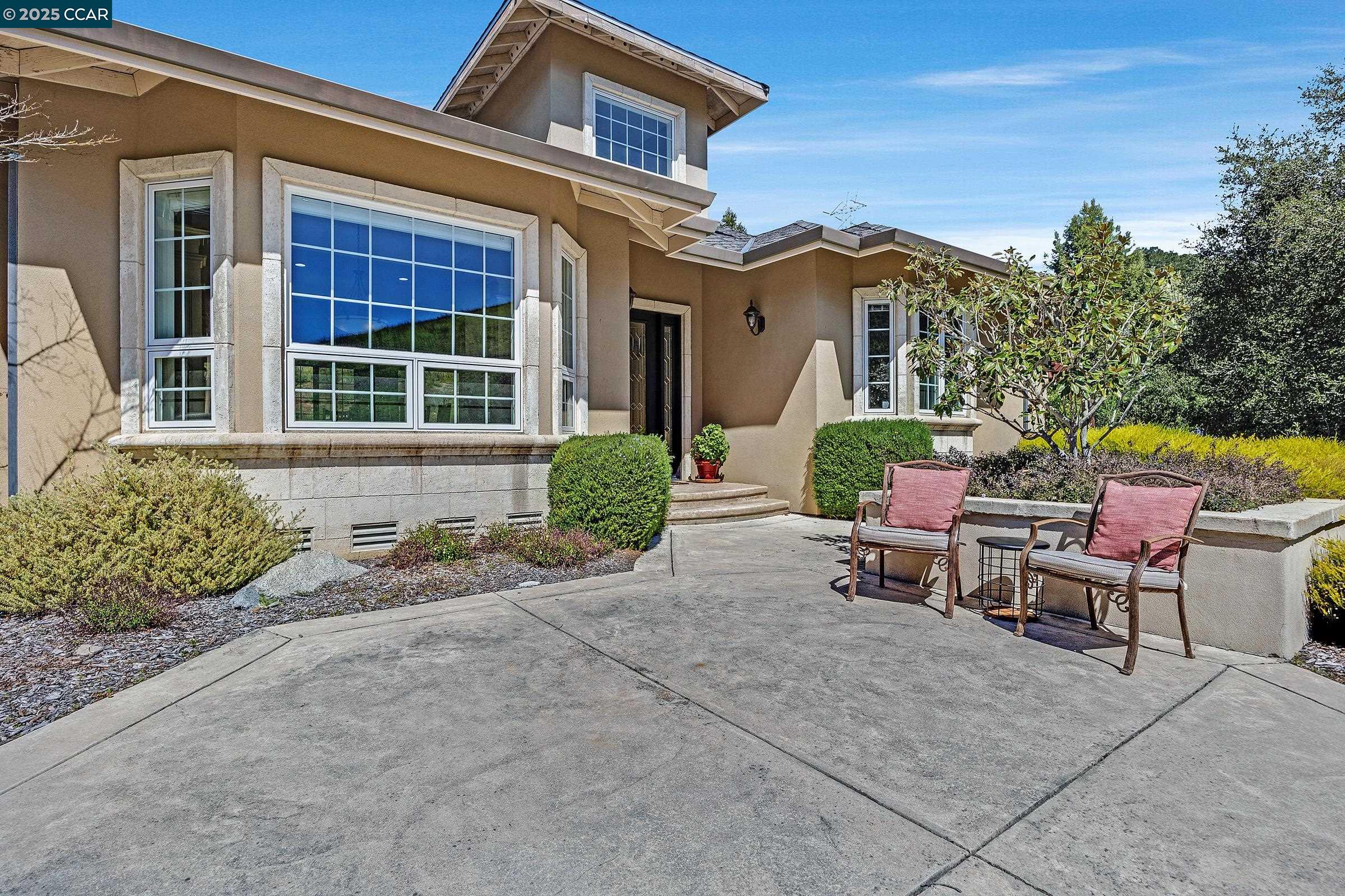 25100 Palomares Road Castro Valley, CA 94552 - Photo 1 of 1 a view of a brick house with chairs and table in a patio