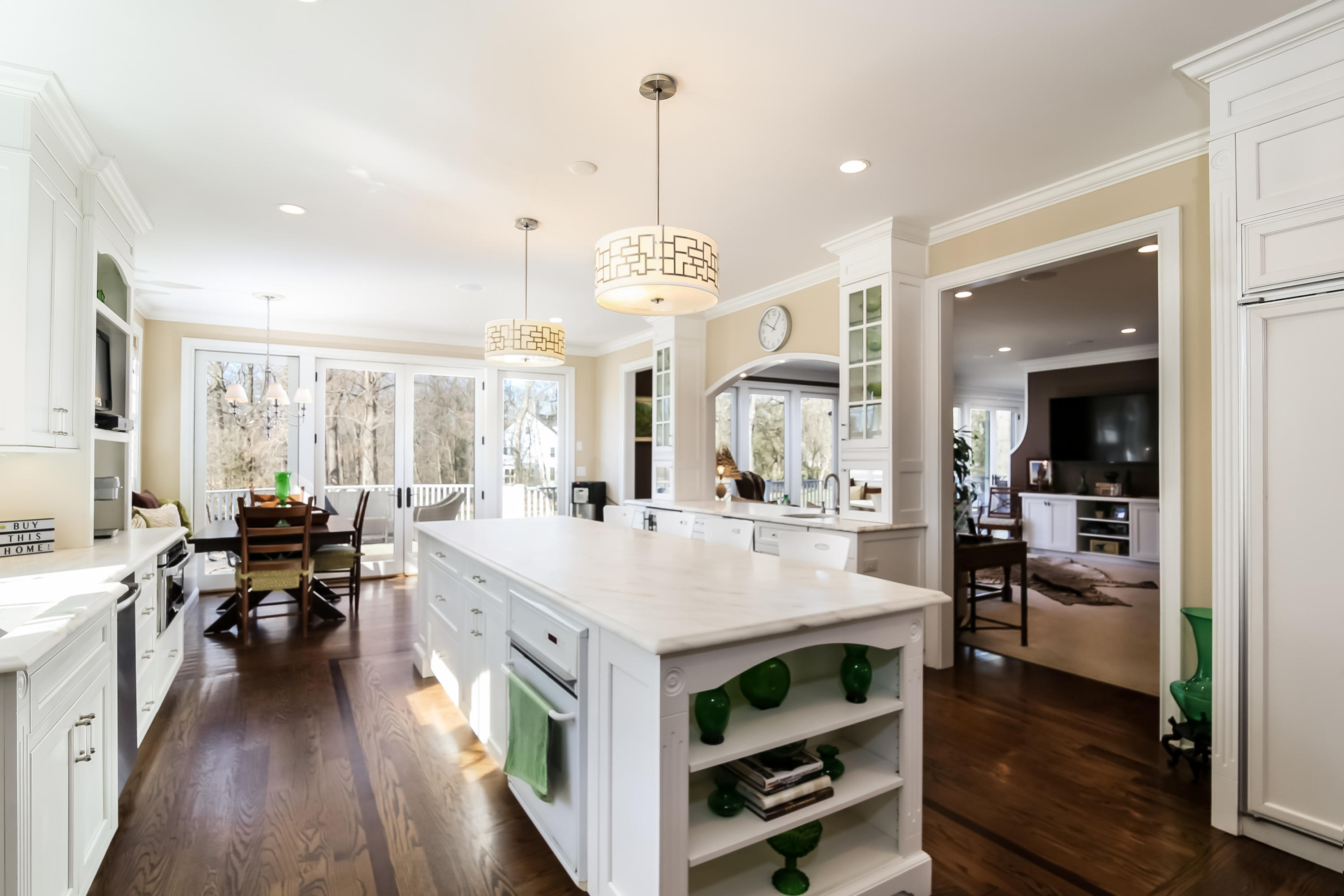 228 Ponus Ridge Road New Canaan, CT 06840 - Photo 11 of 47 a large kitchen with kitchen island a stove a refrigerator a sink dishwasher a dining table and chairs with wooden floor