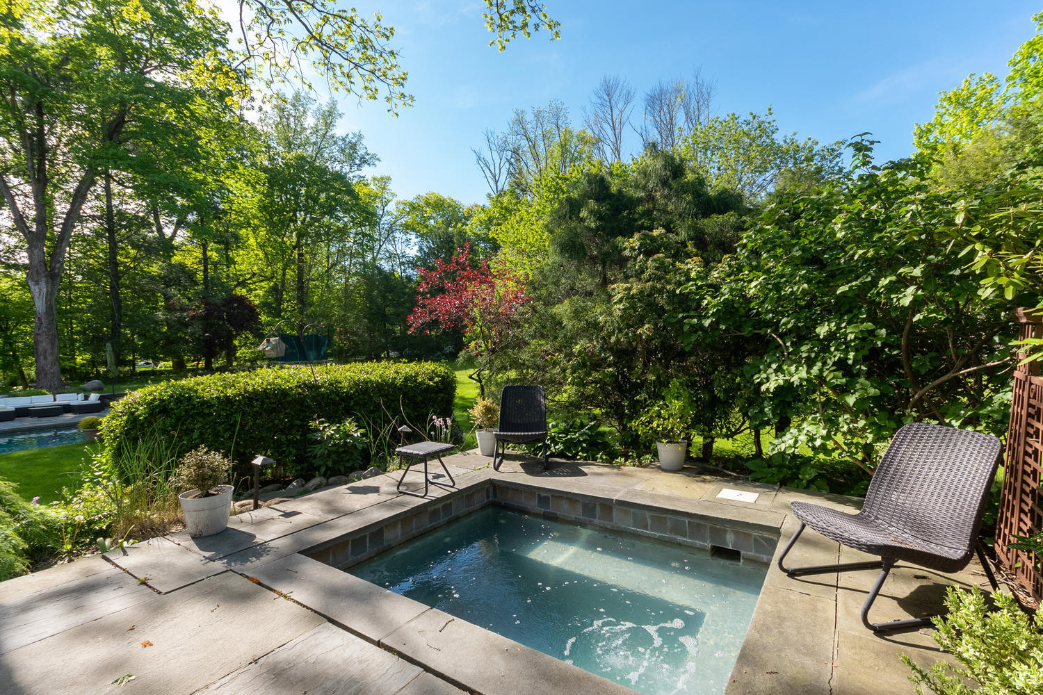 228 Ponus Ridge Road New Canaan, CT 06840 - Photo 34 of 47 a view of a swimming pool with a patio and garden