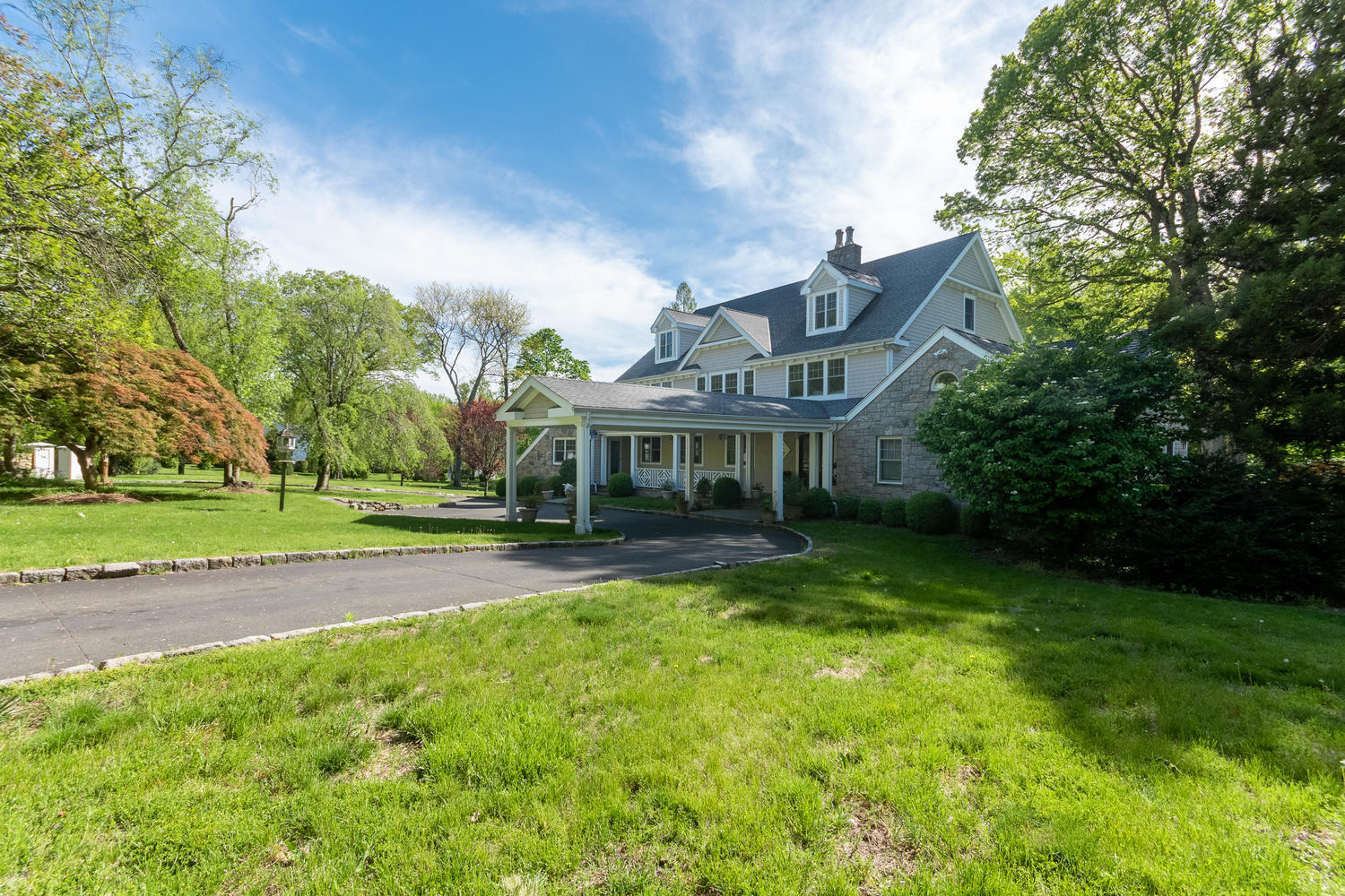 228 Ponus Ridge Road New Canaan, CT 06840 - Photo 35 of 47 a view of a big house with a big yard plants and large trees
