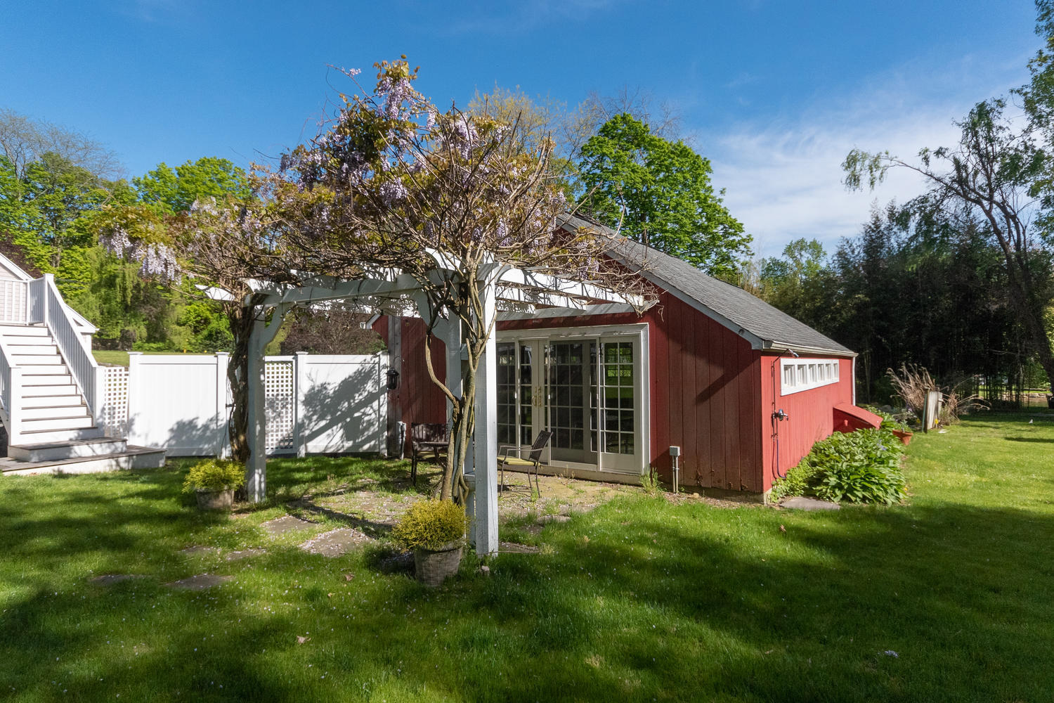 228 Ponus Ridge Road New Canaan, CT 06840 - Photo 40 of 47 a backyard of a house with plants and large tree