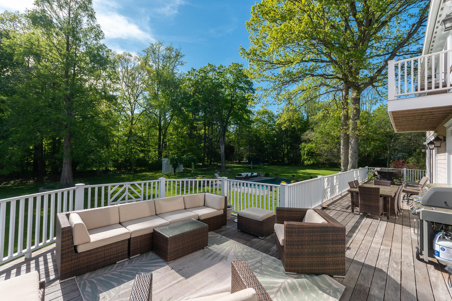 228 Ponus Ridge Road New Canaan, CT 06840 - Photo 43 of 47 a view of a patio with couches and a table and chairs with wooden fence