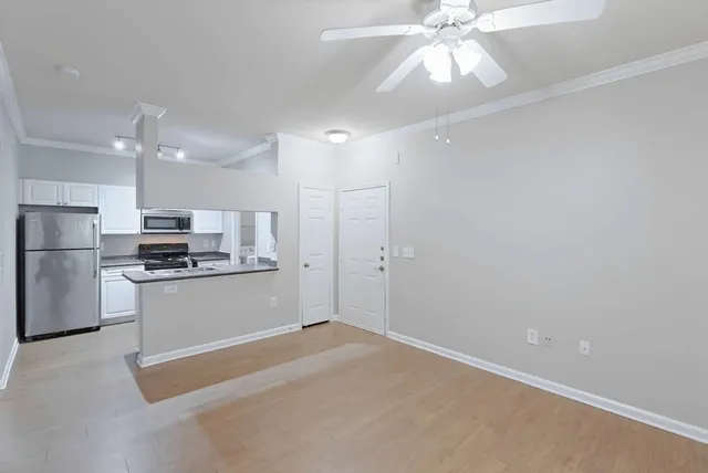 a kitchen with stainless steel appliances granite countertop a refrigerator a oven a sink with a dining table and chairs