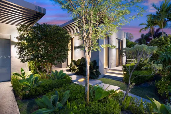 a view of a house with a tree and garden