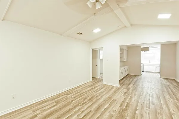 a view of empty room with wooden floor