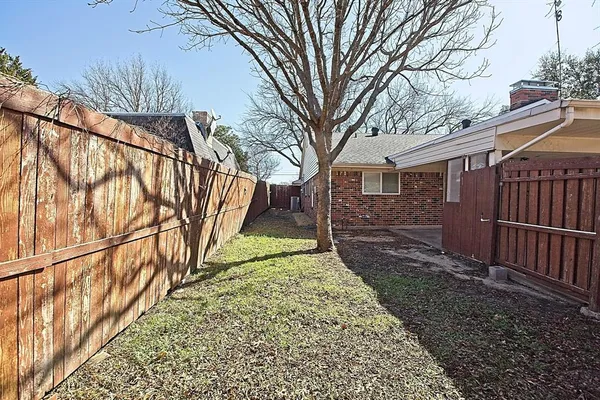 a view of a yard with wooden fence