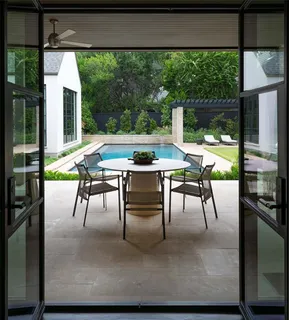 a view of a patio with a table chairs and a floor to ceiling window