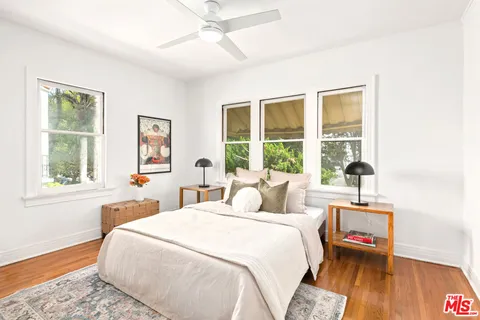 a bedroom with a bed and wooden floor