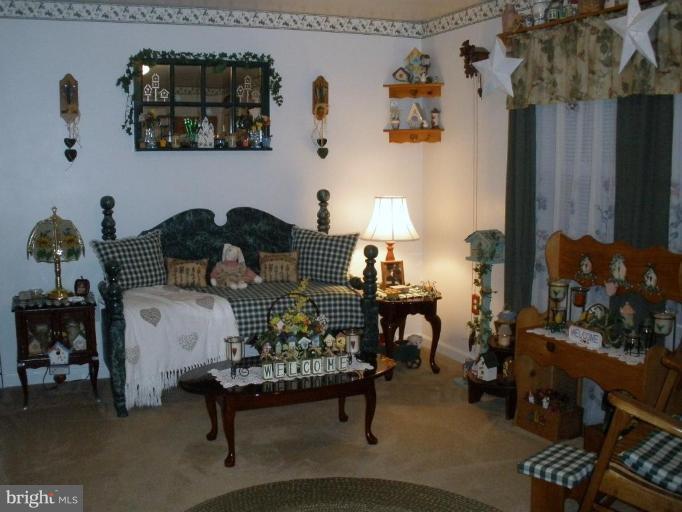 7002 Oliver Beach Road Middle River, MD 21220 - Photo 2 of 12 a bedroom with furniture and a lamp