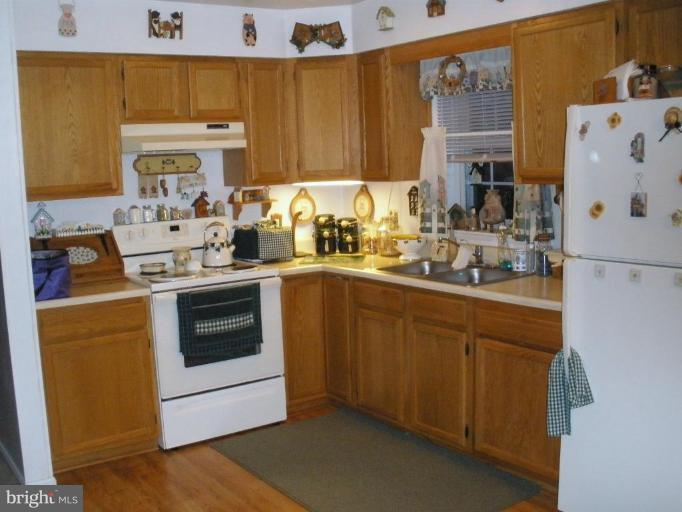 7002 Oliver Beach Road Middle River, MD 21220 - Photo 3 of 12 a kitchen with a white stove top oven sink and cabinets