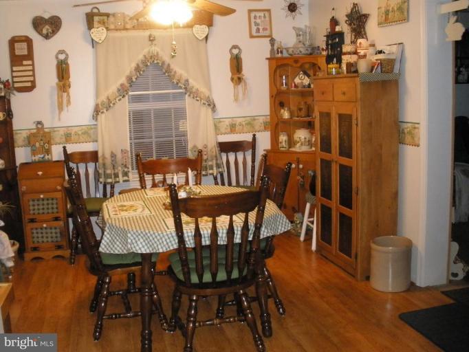 7002 Oliver Beach Road Middle River, MD 21220 - Photo 4 of 12 a view of a dining room with furniture and wooden floor