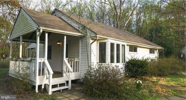 a view of house with backyard and outdoor seating