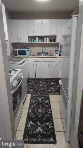 a kitchen with white cabinets and white appliances