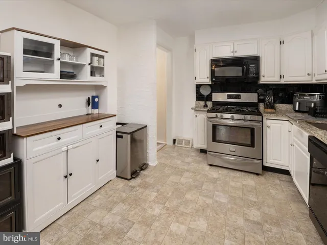 a kitchen with stainless steel appliances a stove a sink and a microwave