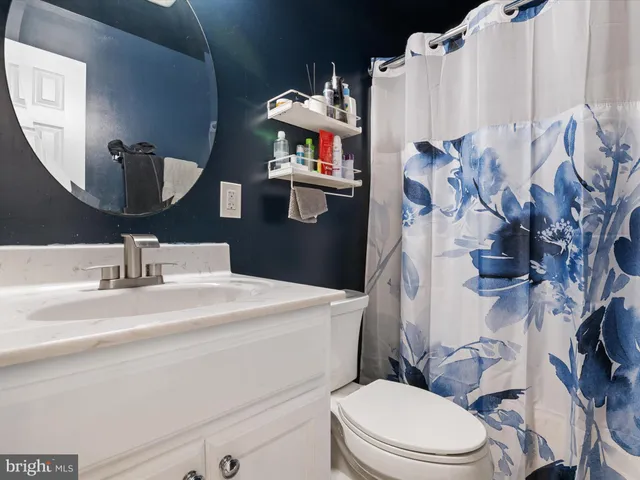 a bathroom with a sink vanity mirror and toilet