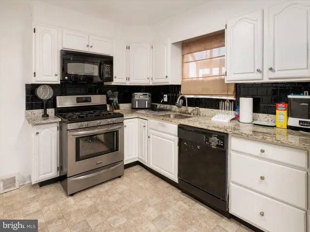 a kitchen with a stove a sink and a microwave
