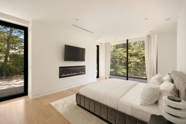 a bedroom with a bed and large windows