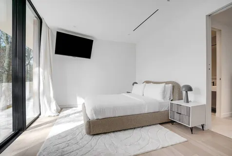 a bedroom with a bed and a flat screen tv