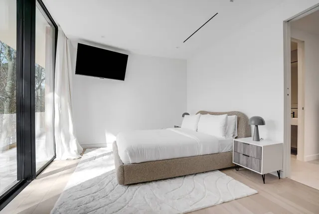 a bedroom with a bed and a flat screen tv