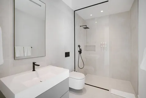 a white toilet sitting next to a bathroom sink