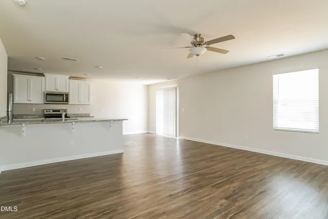 a view of a kitchen with a sink a ceiling fan and wooden floor