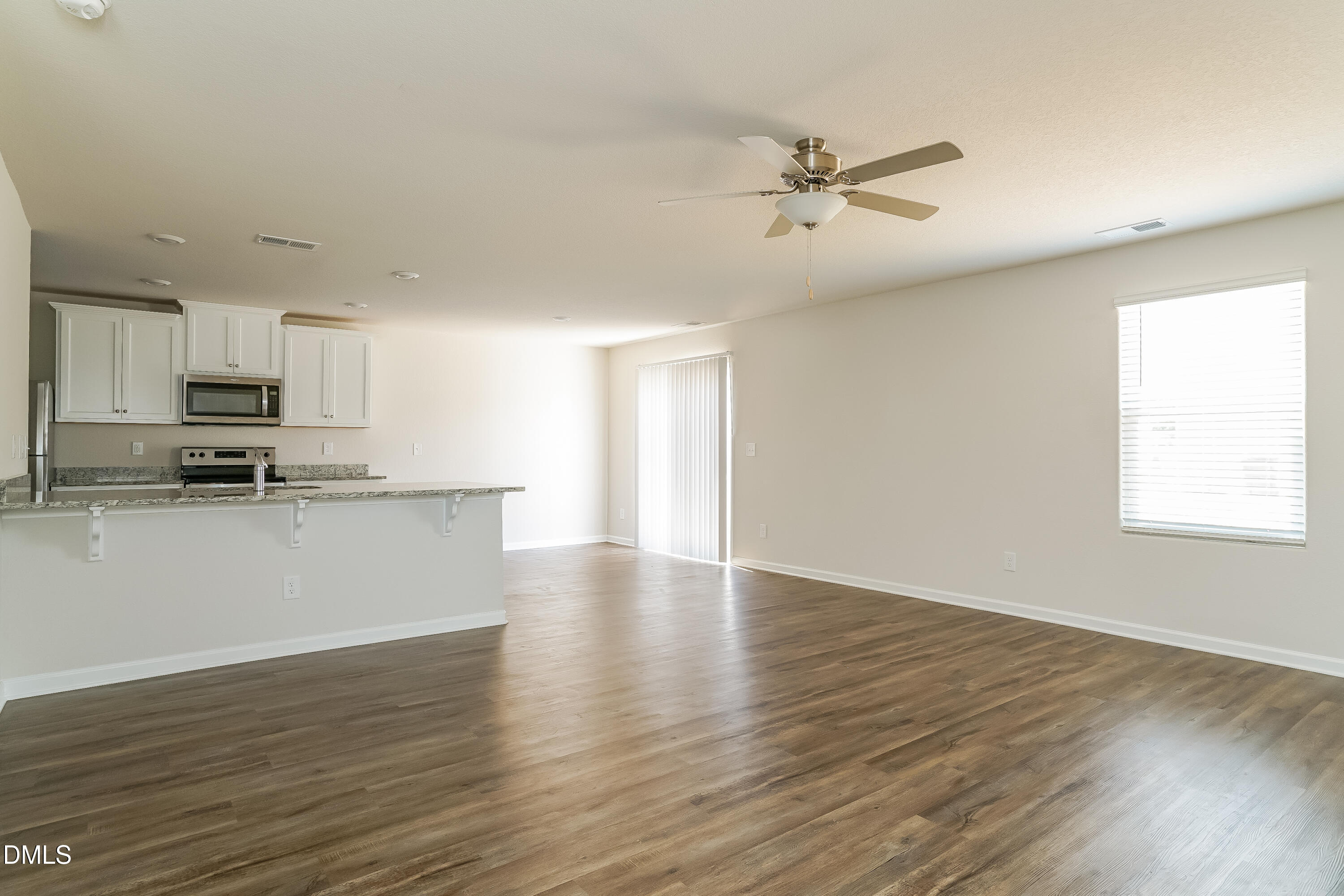 300 Gourd Street Zebulon, NC 27597 - Photo 2 of 17 a view of a kitchen with a sink a ceiling fan and wooden floor