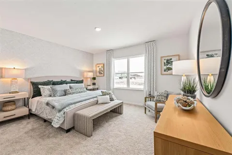 a spacious bedroom with a bed a couch and dresser