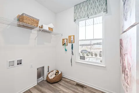 a view of a bedroom with wooden floor and window