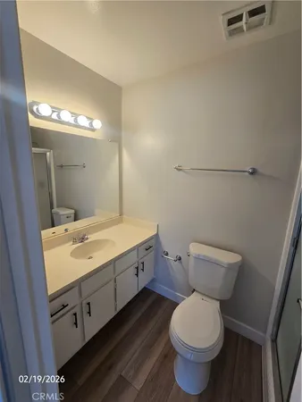 a bathroom with a granite countertop toilet and a sink