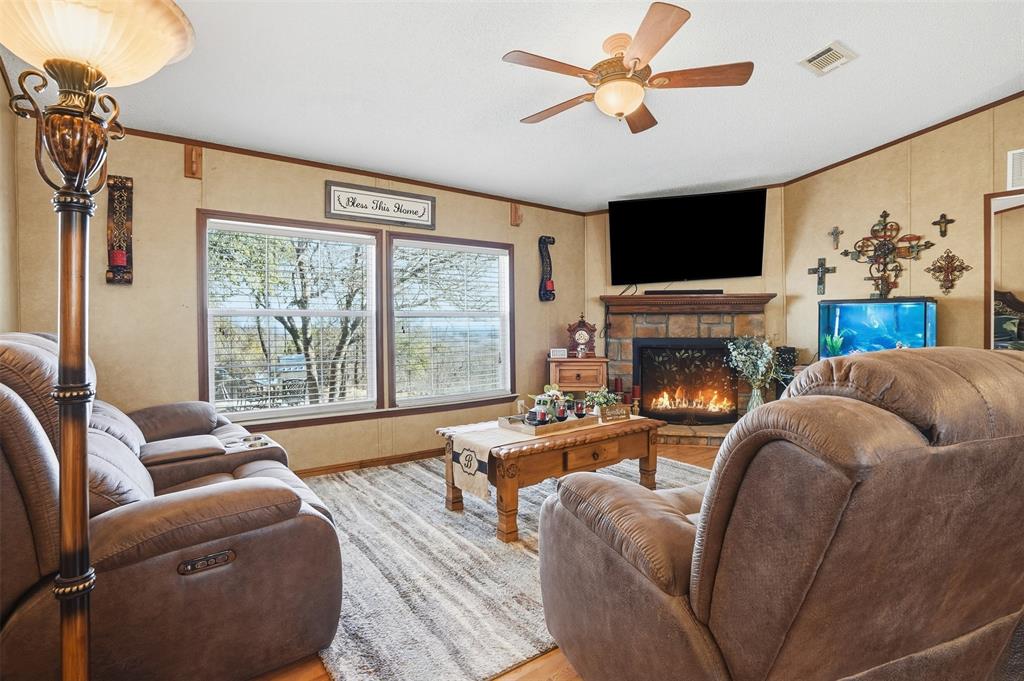 224 Cactus Ridge Court Springtown, TX 76082 - Photo 11 of 39 Living area featuring a stone wood burning fireplace