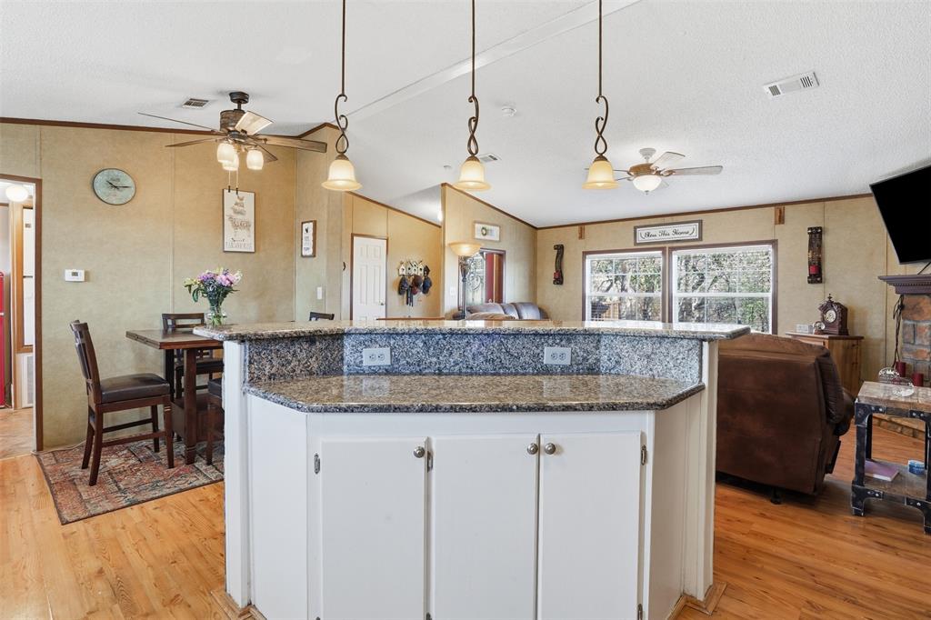 224 Cactus Ridge Court Springtown, TX 76082 - Photo 39 of 39 Kitchen featuring ceiling fan, white cabinetry, decorative light fixtures, open floor plan, and vaulted ceiling