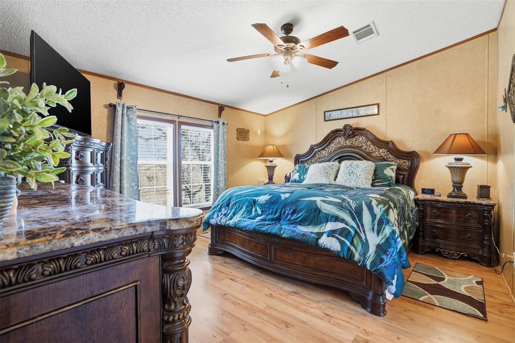 224 Cactus Ridge Court Springtown, TX 76082 - Photo 20 of 39 Primary bedroom featuring ornamental molding, vaulted ceiling, light wood finished floors, a ceiling fan