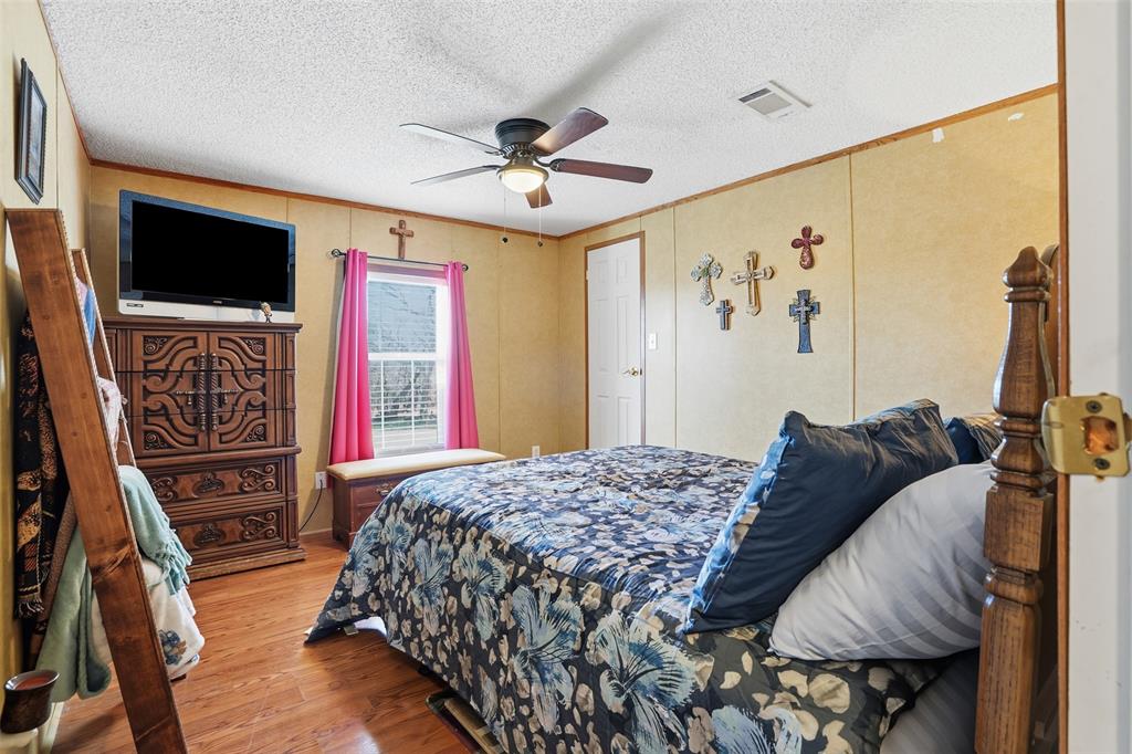 224 Cactus Ridge Court Springtown, TX 76082 - Photo 23 of 39 Third bedroom with wood finished floors, ceiling fan, ornamental molding