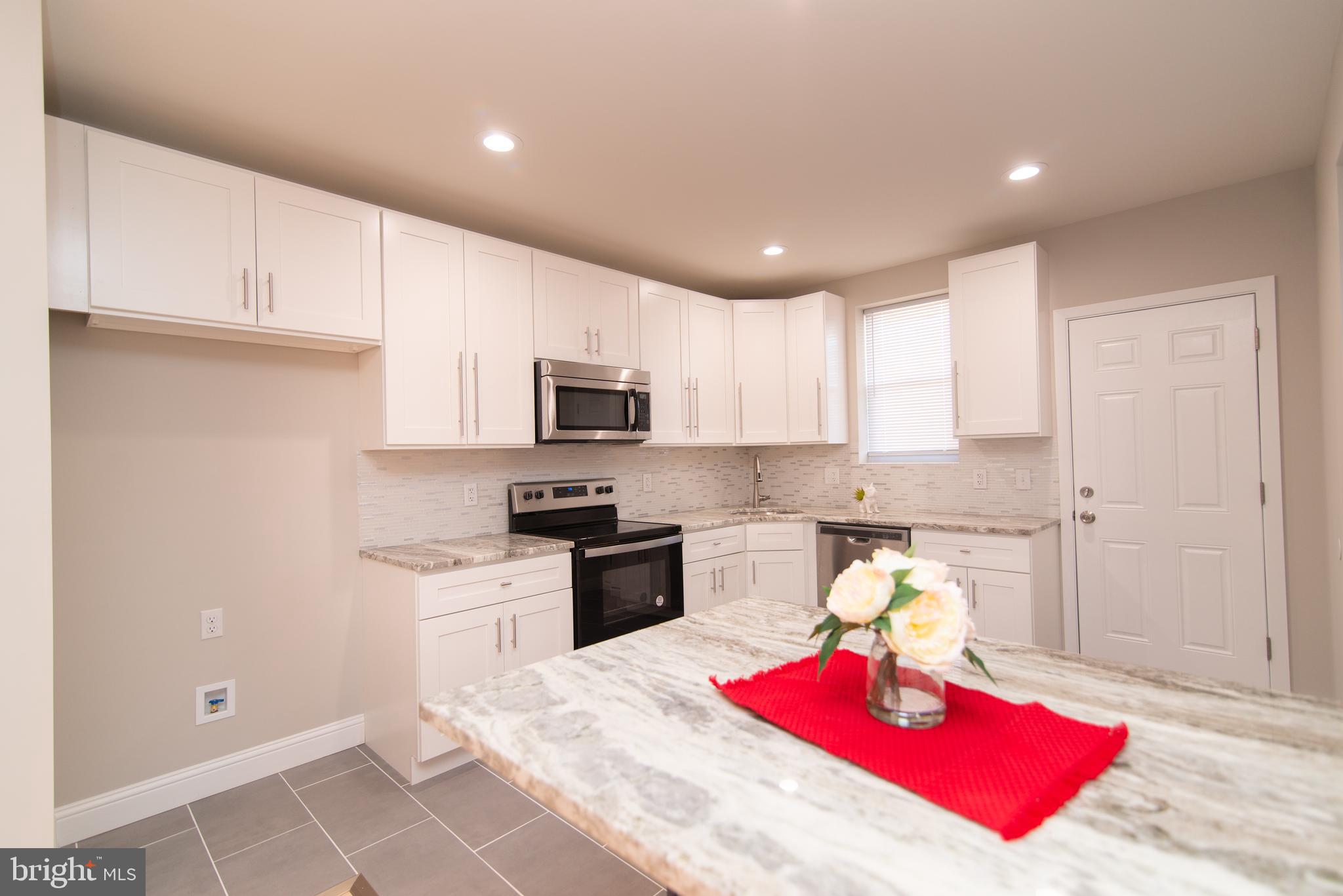a kitchen with stainless steel appliances granite countertop a sink dishwasher stove top oven and cabinets