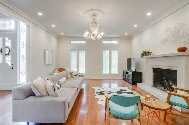 a living room with furniture a fireplace and a chandelier