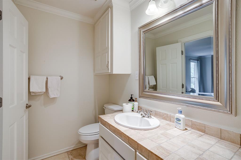 1805 Burton Hill Road Fort Worth, TX 76107 - Photo 30 of 39 a bathroom with a sink vanity mirror and toilet