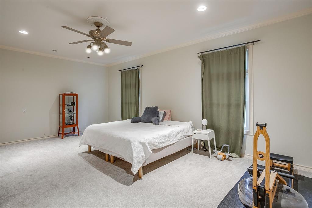 1805 Burton Hill Road Fort Worth, TX 76107 - Photo 34 of 39 a bedroom with a bed and a chandelier