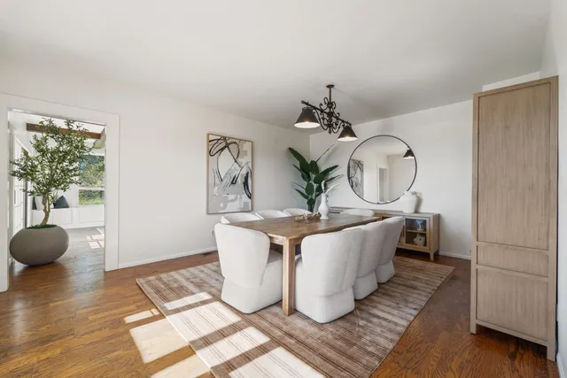 a living room with furniture a mirror and wooden floor