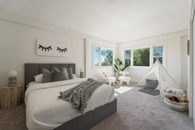 a living room with chairs a rug and a potted plant