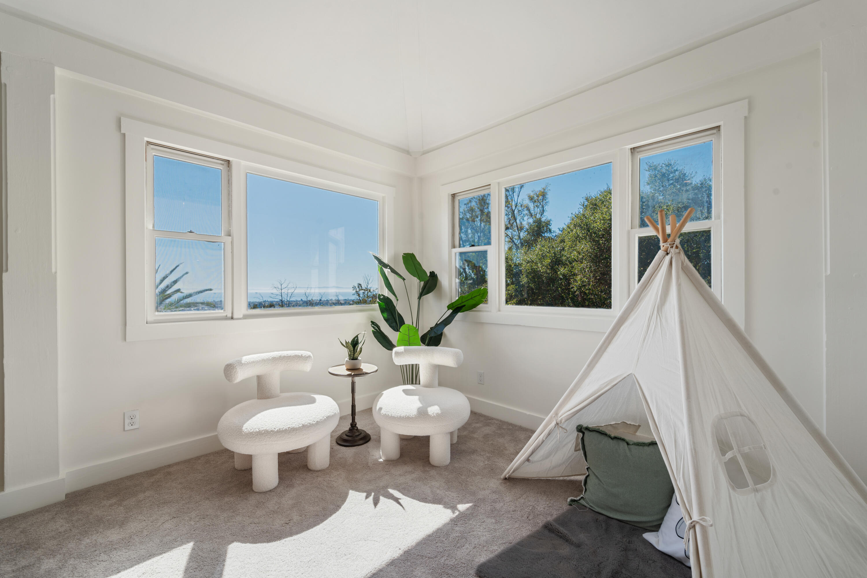 4508 Foothill Road Carpinteria, CA 93013 - Photo 24 of 31 a living room with chairs a rug and a potted plant