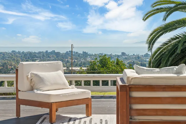 a view of a livingroom with furniture a hardwood floor and staircase