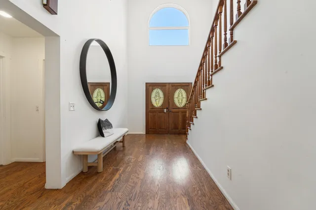 a living room with wooden floor furniture and a chandelier