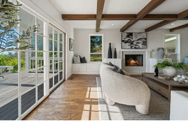 a living room with fireplace furniture and a large window