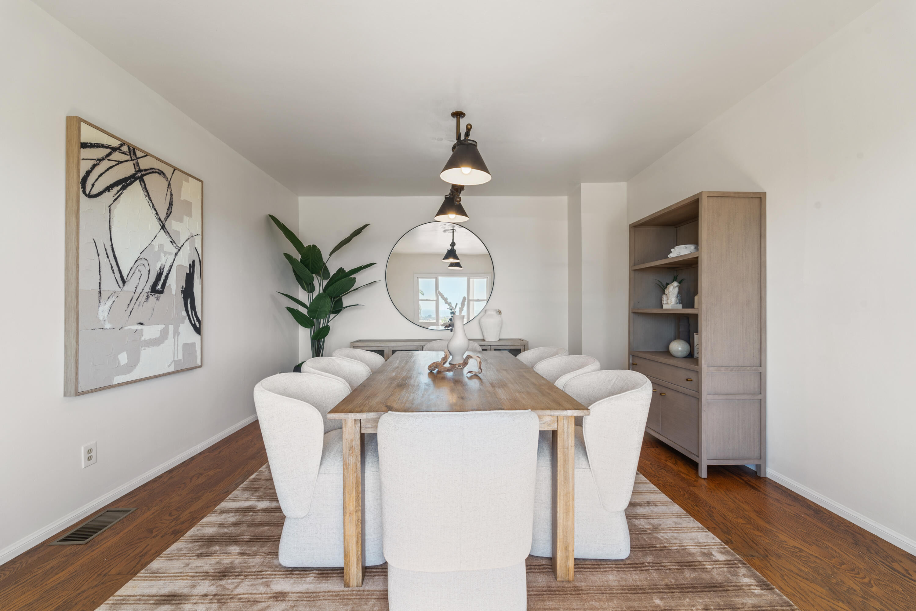 4508 Foothill Road Carpinteria, CA 93013 - Photo 10 of 31 a dining room with wooden floor a chandelier a wooden table and chairs